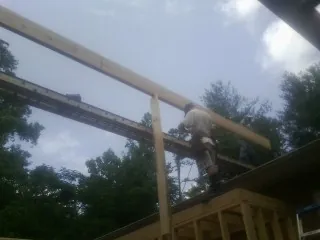 Carpenter setting a ridge beam over a new addition frame — Ice Dam Removal by Roofing Brothers in West Sand Lake