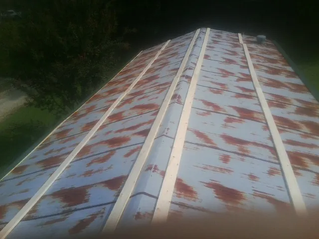 Rusted metal roof panels with new wood purlins before replacement — Storm Damage Roof Repair in West Sand Lake by Roofing Brothers