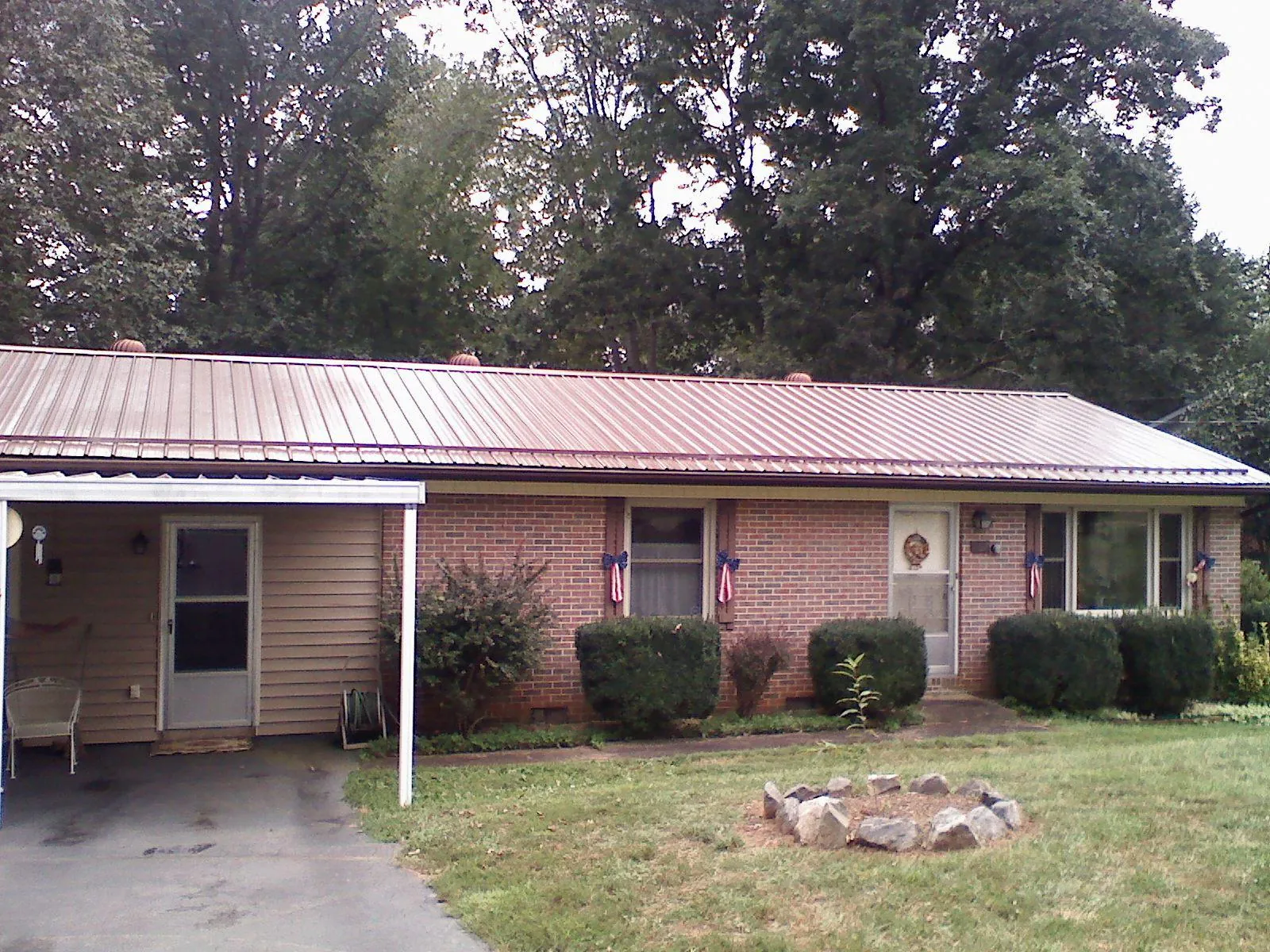 Bronze metal roof and carport on a brick ranch home — Roof Repair work by our crew in West Sand Lake